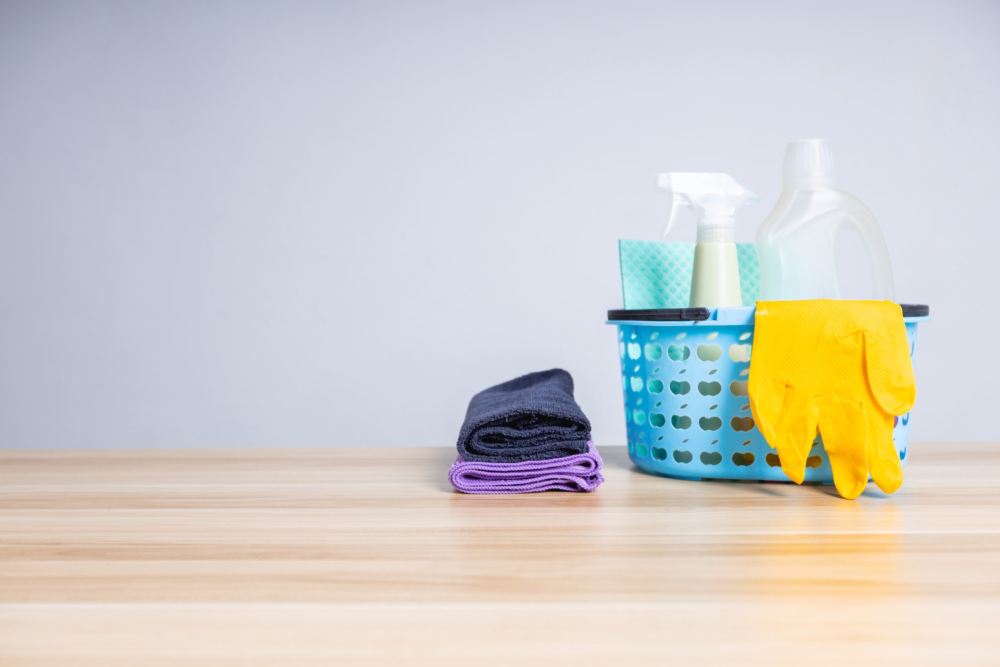 Basket of Cleaning Supplies on Wooden Table